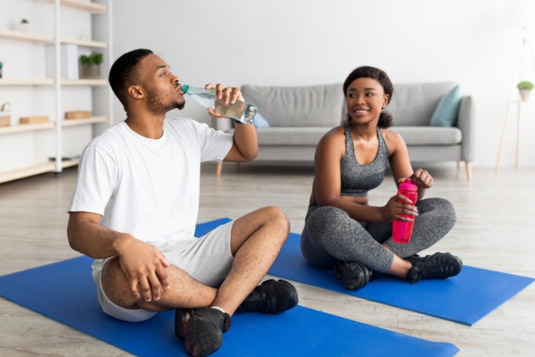 couple working out and staying hydrated indoors