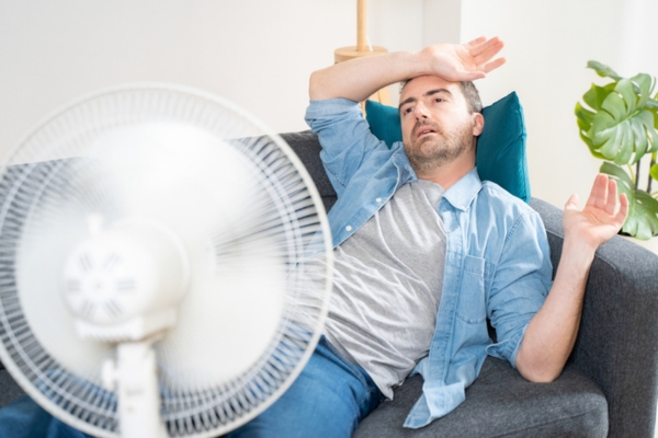 man feeling heat exhaustion in the middle of summer