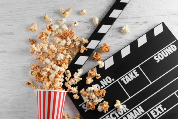 pop corn in a bucket and movie clapper depicting summer blockbuster