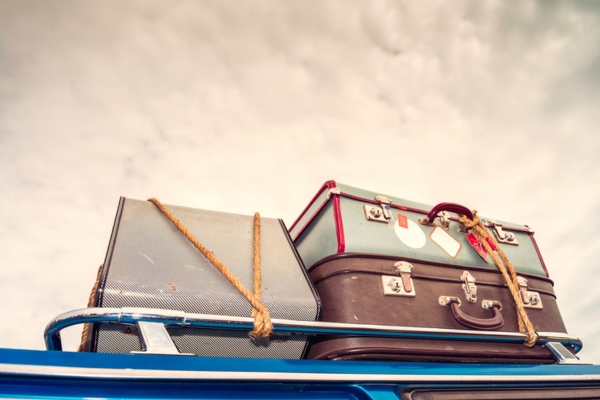 vintage suitcases on top of car depicting month long summer vacations