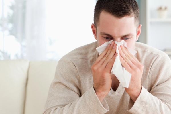 Tired man blowing his nose depicting airborne disease