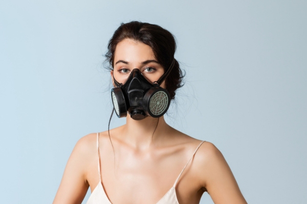 woman wearing gas mask depicting gas smell from air conditioner