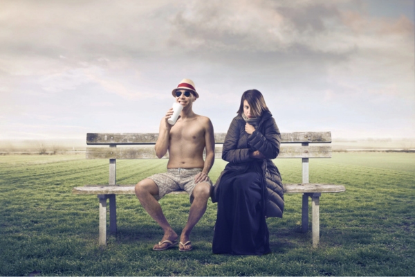 topless man enjoying a cold drink beside a woman in full winter outfit depicting uneven & inconsistent heating